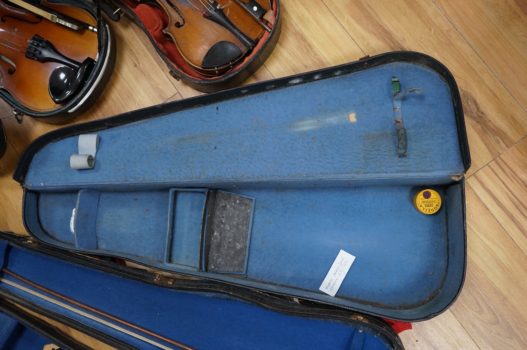 Five cased 20th century violins, including; a German violin, two Czech violins, a three-quarter size violin with a label for Bienfait, and a Romanian quarter size violin, all in cases or the remains of cases.